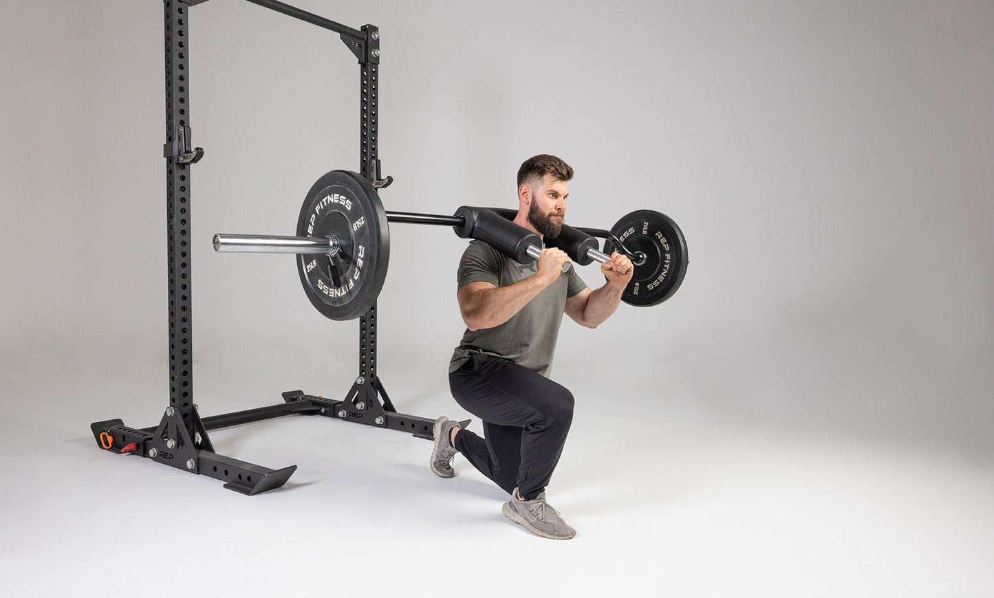 Lifter performing a lunge with a weighted Safety Squat Bar.